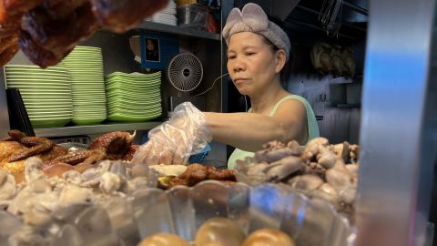 Chicken rice seller Madam Tong prepares a dish for a customer.