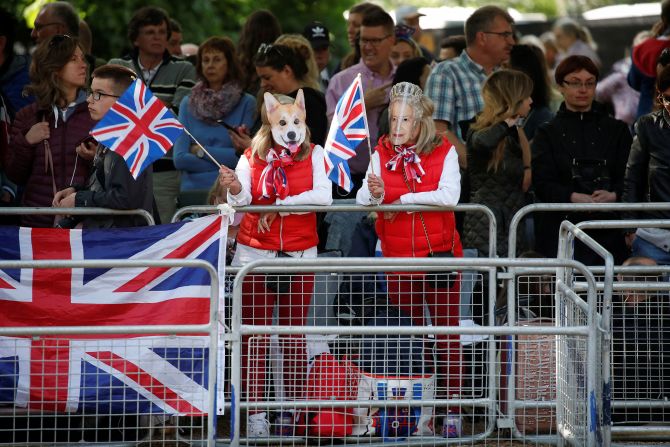 People wear masks of the Queen and one of her dogs as they attend jubilee celebrations on The Mall on Thursday.