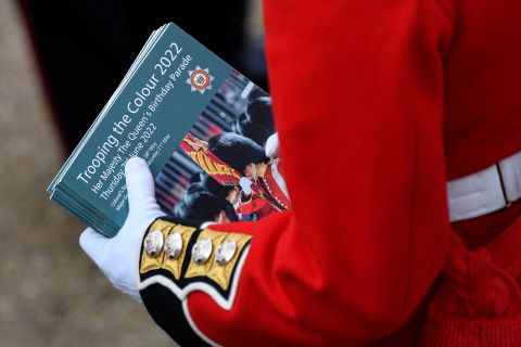 A member of the Coldstream Guards holds souvenir programs ahead of the start of Thursday's parade.
