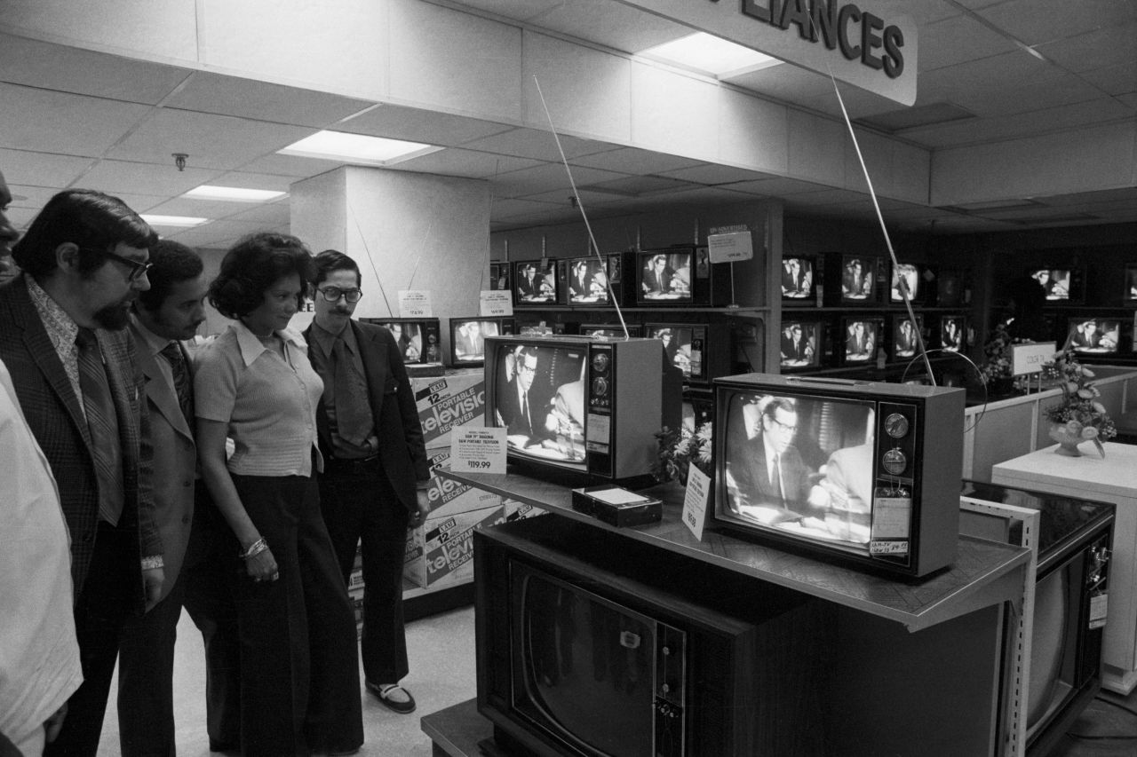 People watch the start of the hearings from a department store in New York.