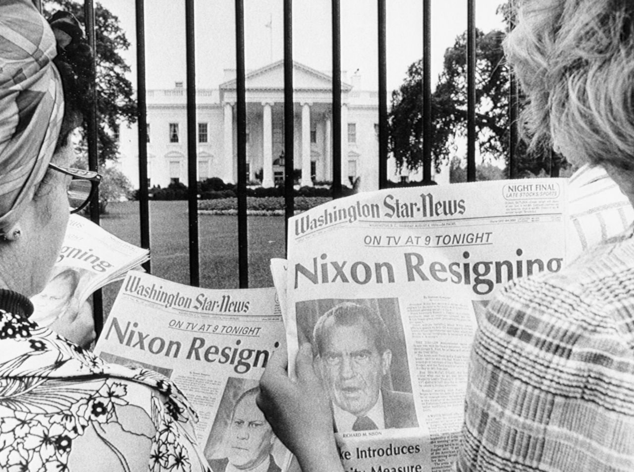 Tourists outside the White House read news of Nixon's impending resignation on August 8, 1974.