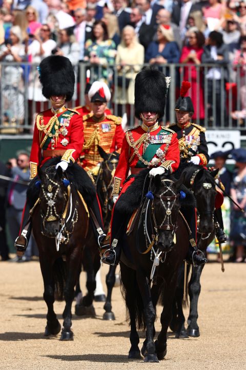 Prince William, left, rides on horseback next to his father, Prince Charles, during the Trooping the Colour parade.