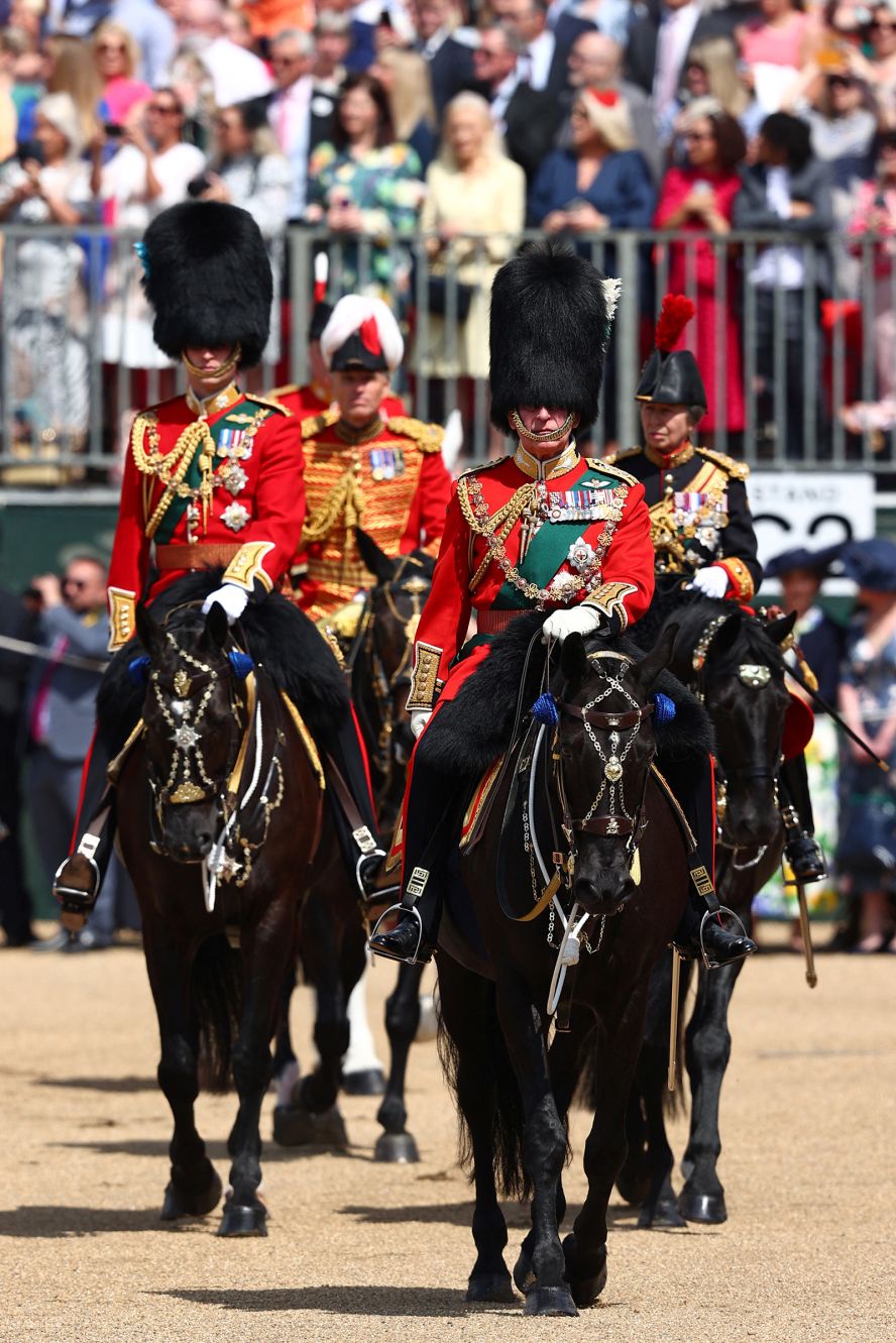 Prince William, left, rides on horseback next to his father, Prince Charles, during the Trooping the Colour parade.