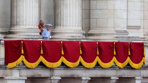 The Queen walks out onto the Buckingham Palace balcony.