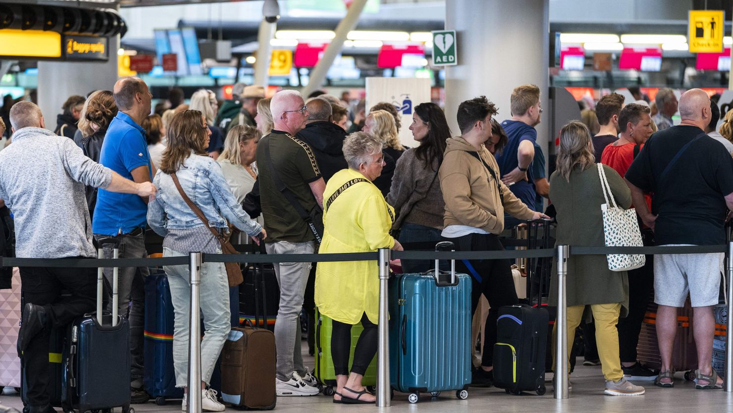 Travellers queue, many going away for the long weekend on Ascension Day, in the departure hall of Schiphol Airport, near Amsterdam on May 26, 2022.