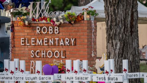 A makeshift memorial surrounds the Robb Elementary School sign following the mass shooting at the Uvalde, Texas, school on May 26.
