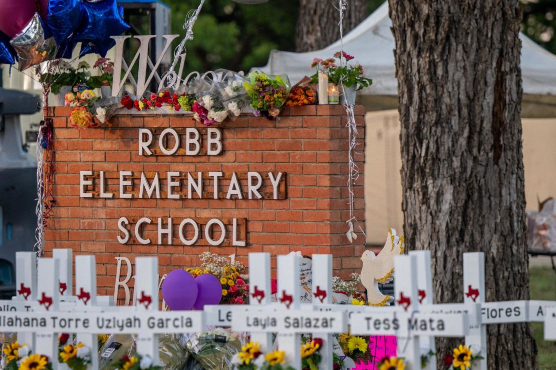 A makeshift memorial surrounds the Robb Elementary School sign following the mass shooting at the Uvalde, Texas, school on May 26.