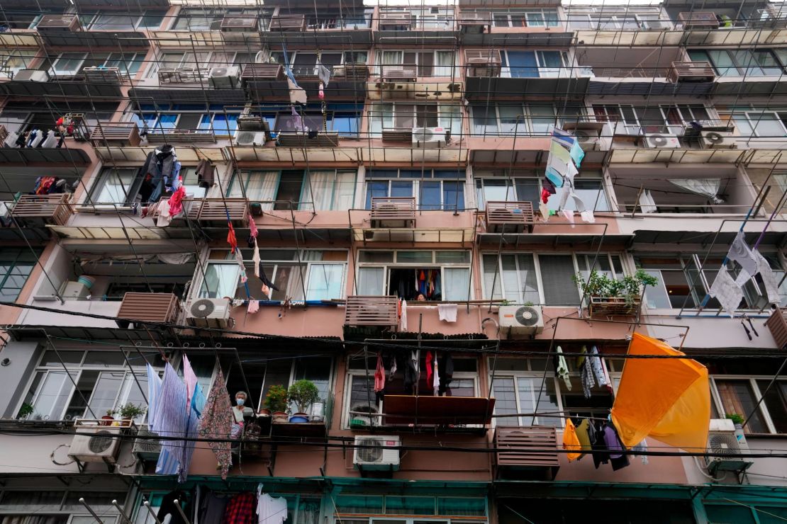 A resident wearing a mask looks out from his home in Shanghai on Thursday. 