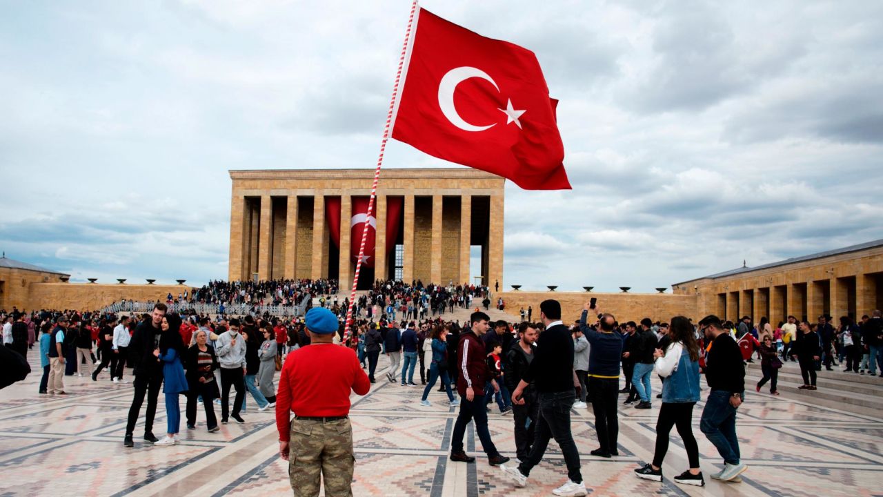 A man stands with a national flag as people visit the mausoleum of Mustafa Kemal Ataturk, the founder of modern Turkey, in Ankara on May 19.