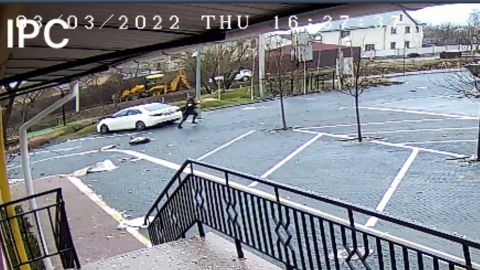 This picture taken from a security camera at the Pokrovsky residential complex shows in the far background the abandoned excavator and the white car in which the mayor was traveling.