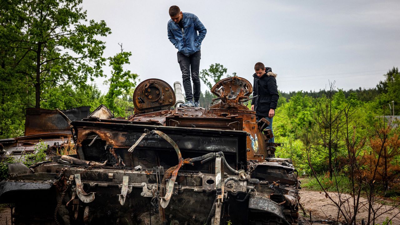 Local residents examine a destroyed Russian tank outside of Kyiv, Ukraine, on Tuesday, May 31. It has now been 100 days since Russia invaded.  Zelensky says Russia waging war so Putin can stay in power &#8216;until the end of his life&#8217; 220603085737 kyiv ukraine tank 0531