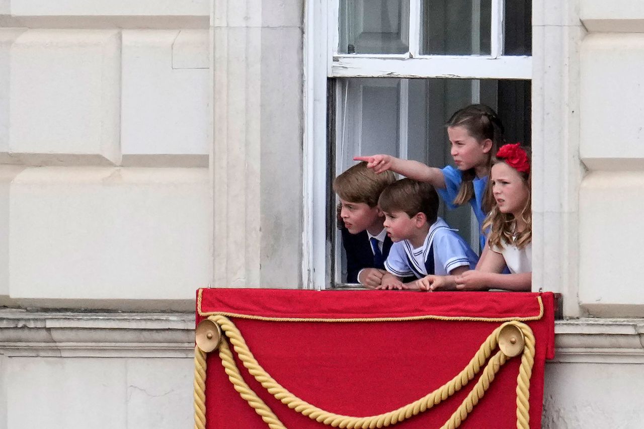 Four of the Queen's great-grandchildren watch the parade from a window of Buckinghamp Palace on Thursday. From left are Prince George, Prince Louis, Princess Charlotte and Mia Tindall.