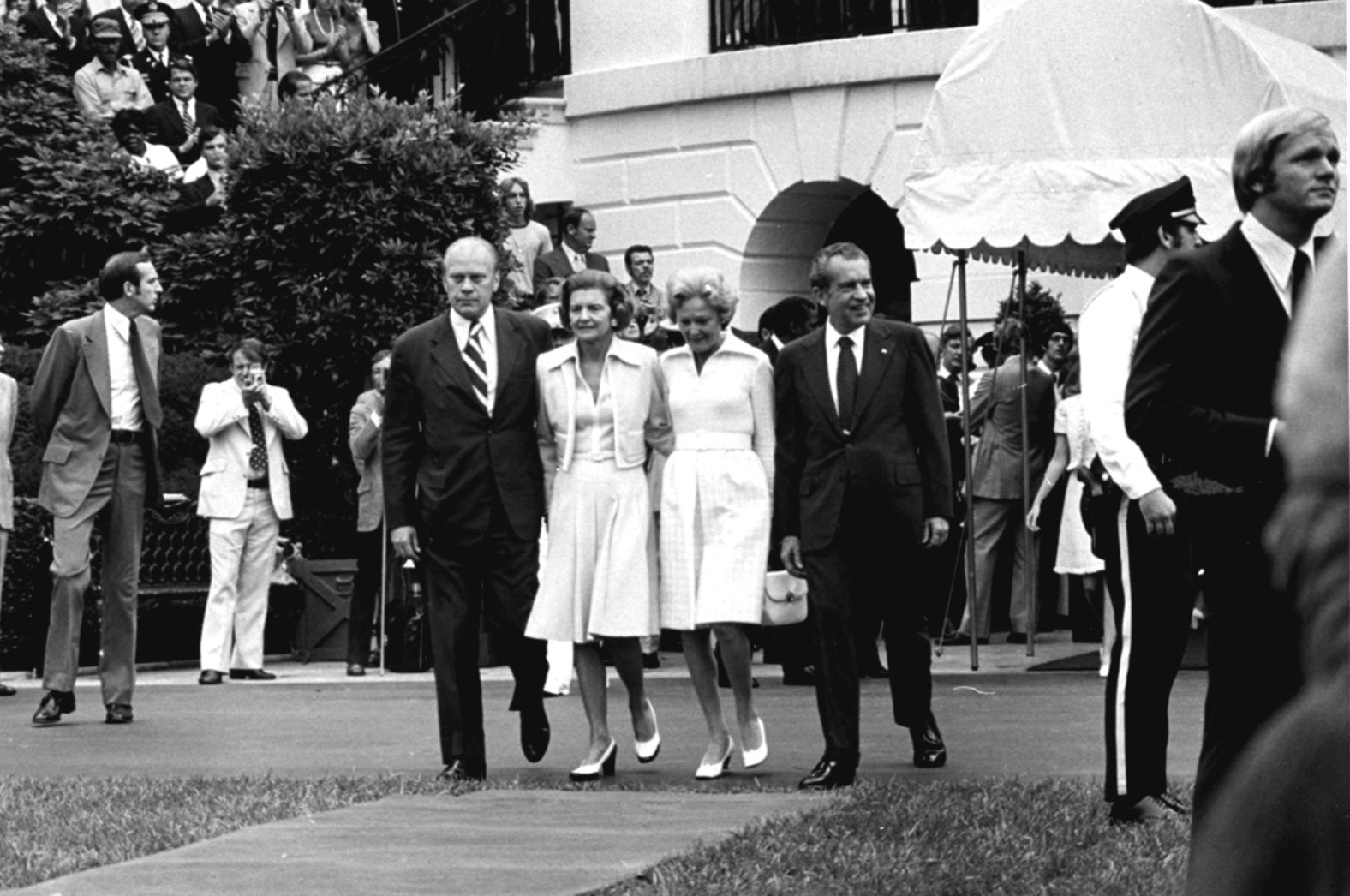 Nixon and his wife, Pat, walk out of the White House with Ford and his wife, Betty, before boarding Marine One. Nixon was pardoned by Ford a month later.