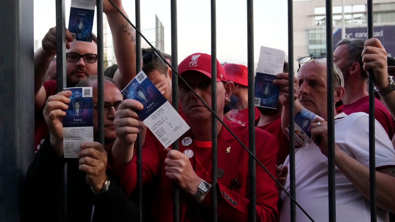 Liverpool fans show tickets and wait in front of the Stade de France prior to the Champions League Final.