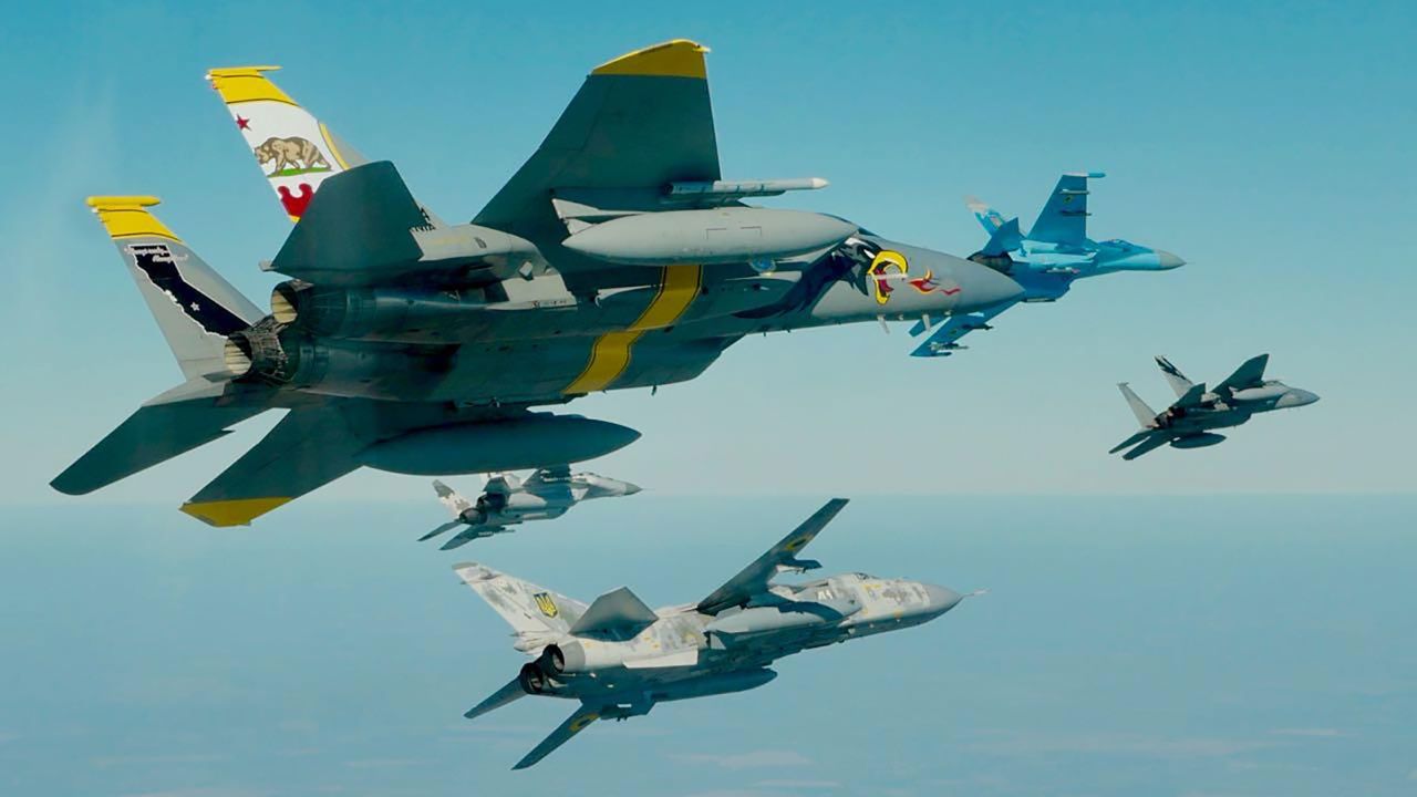 A California Air National Guard F-15 Eagle (foreground, left) flies with a Ukrainian Sukhoi Su-24 (bottom, center) and a Ukrainian MiG-29 (top right) during the 2018 Clear Sky exercise. Another F-15 (right, center) leads the formation.