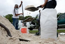 People fill sandbags as they prepare their homes for the expected arrival of a tropical storm Friday in Pembroke Pines, Fla.