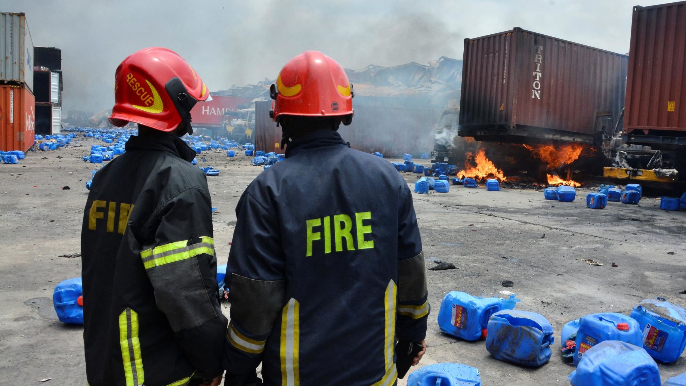 Firefighters assess the damage at the site of the fire. 