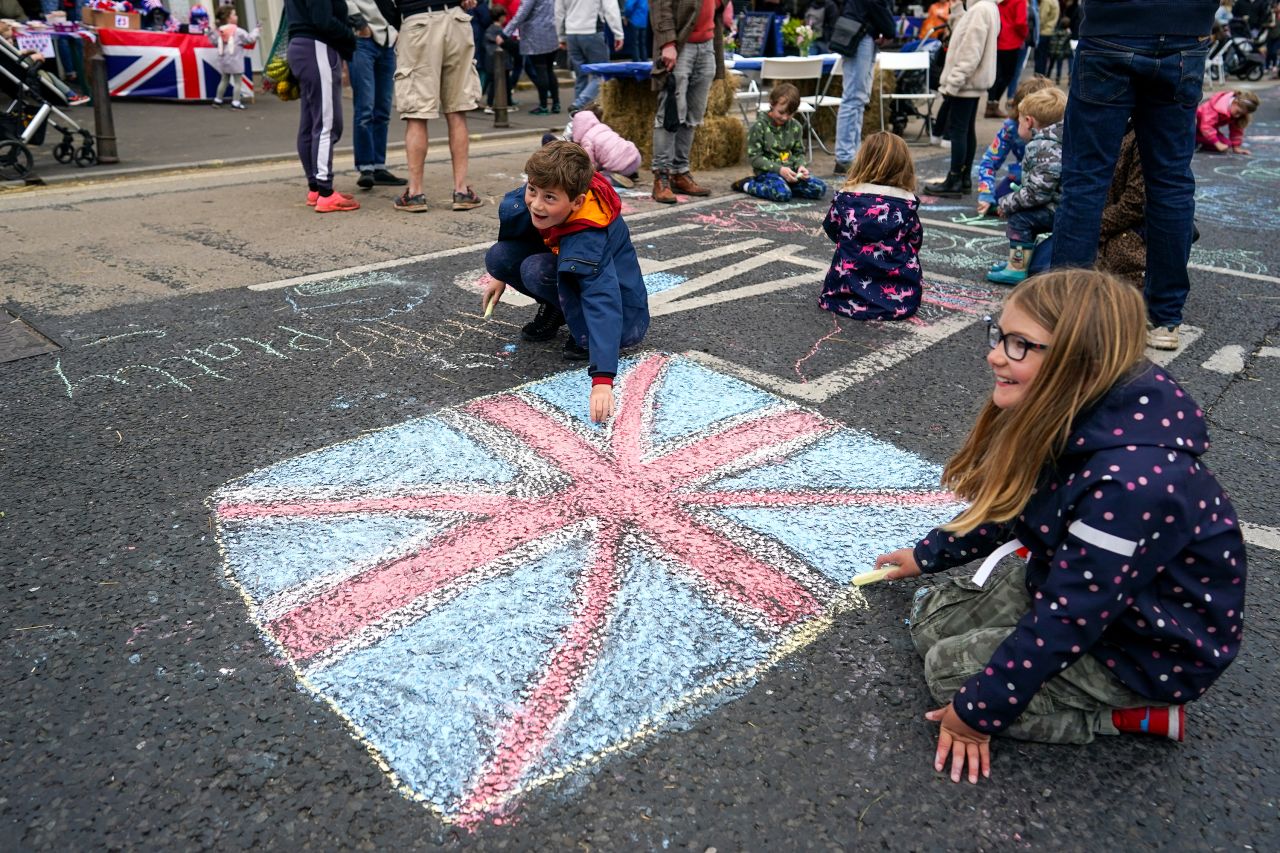 Children chalk a flag on the road during a street party in York, England, in Sunday.