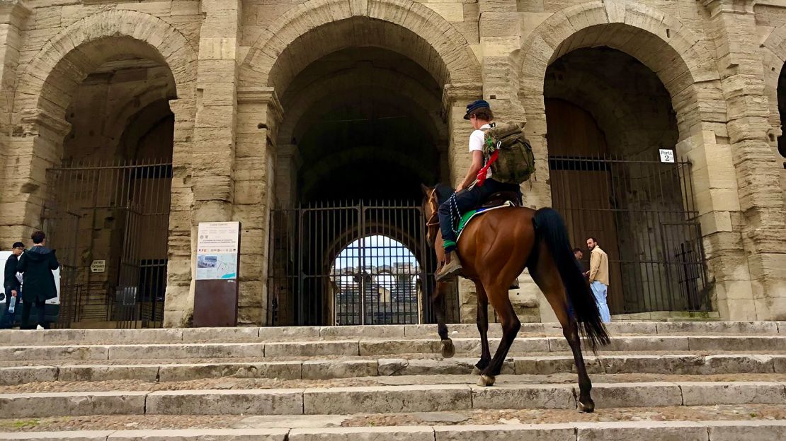 Hall climbs the steps of the Arles Amphitheatre in France with Sasha.