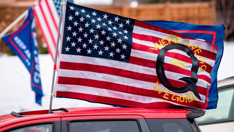 ST PAUL, MN - NOVEMBER 14: A car with a flag endorsing the QAnon drives by as supporters of President Donald Trump gather for a rally outside the Governor's Mansion on November 14, 2020 in St Paul, Minnesota. Thousands have gathered in cities around the country today to contest the results of the election earlier this month. (Photo by Stephen Maturen/Getty Images)