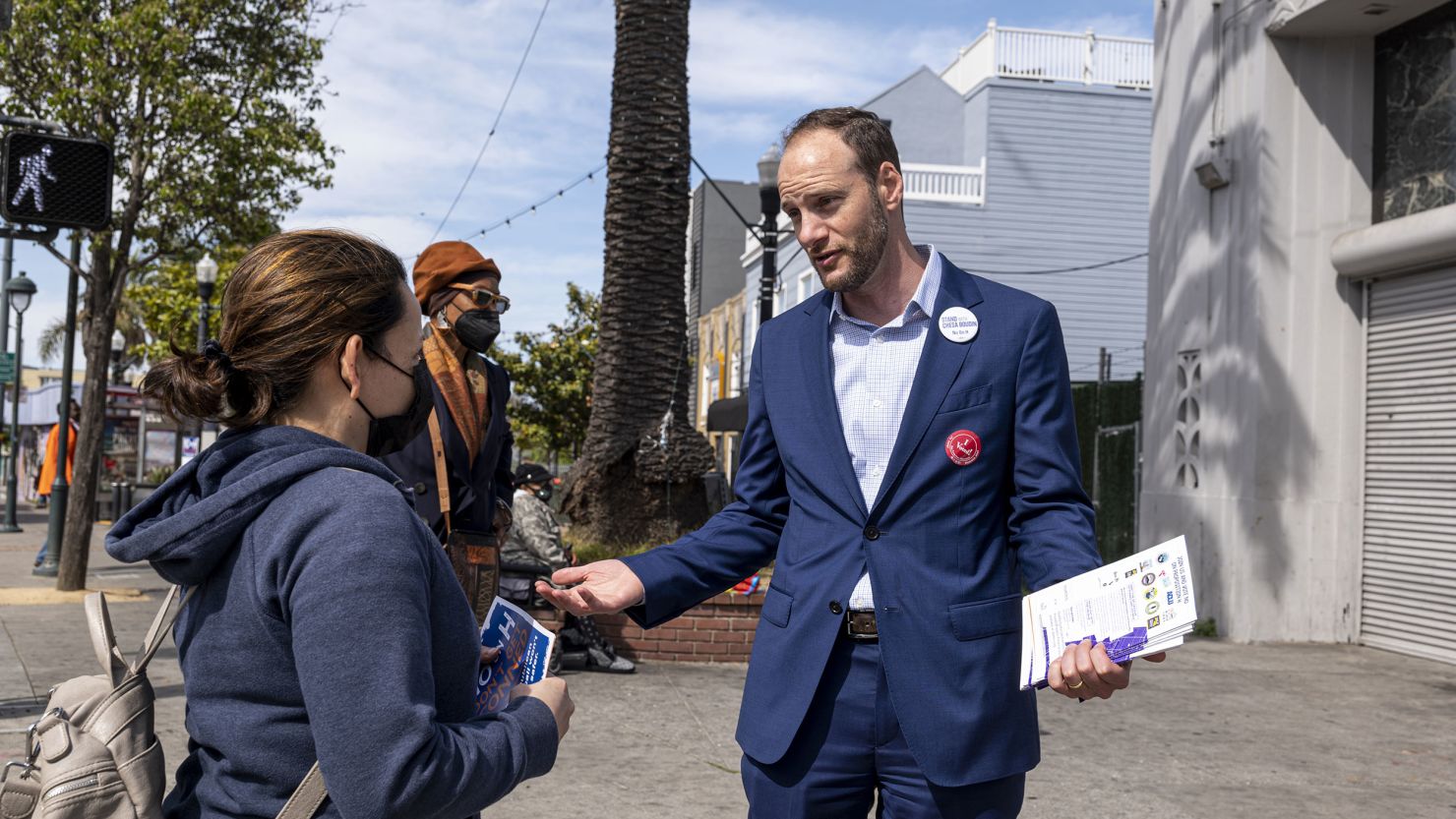 Chesa Boudin, here speaking with a resident of San Francisco on June 7, 2022, was ousted as the city's district attorney in a recall election. 