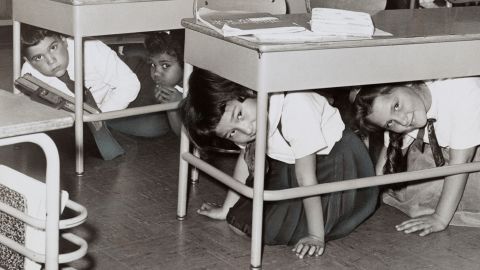 Students at a Brooklyn middle school 'duck and cover' during a practice drill for a nuclear attack in 1962.