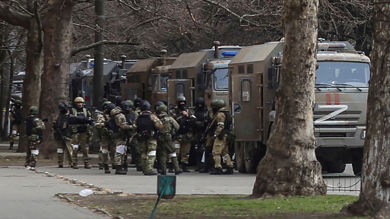 Russian army soldiers stand next to their trucks during a rally against Russian occupation in Svobody (Freedom) Square in Kherson on March 7, 2022.