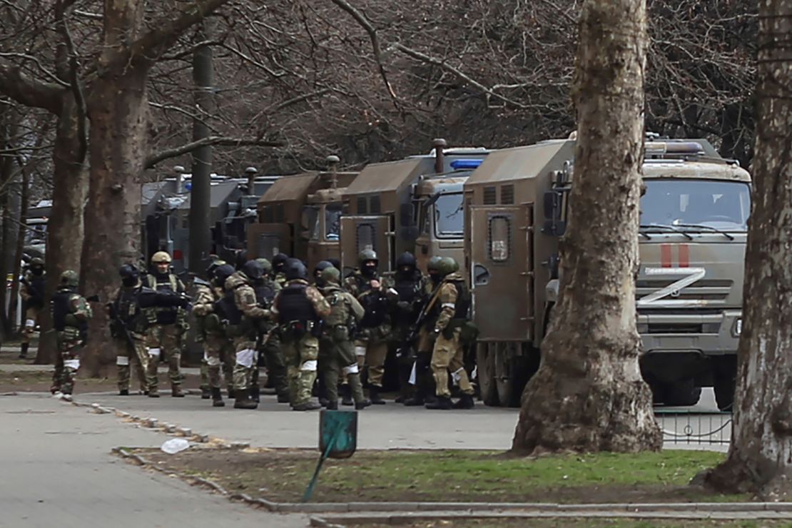 Russian army soldiers stand next to their trucks during a rally against Russian occupation in Svobody (Freedom) Square in Kherson on March 7, 2022.