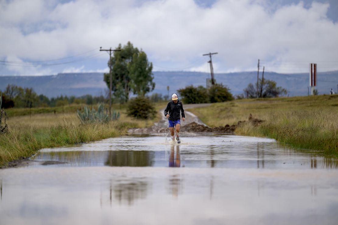 Sandes fording a river during the 16-day run around Lesotho. He says he went through a pair of socks every day.