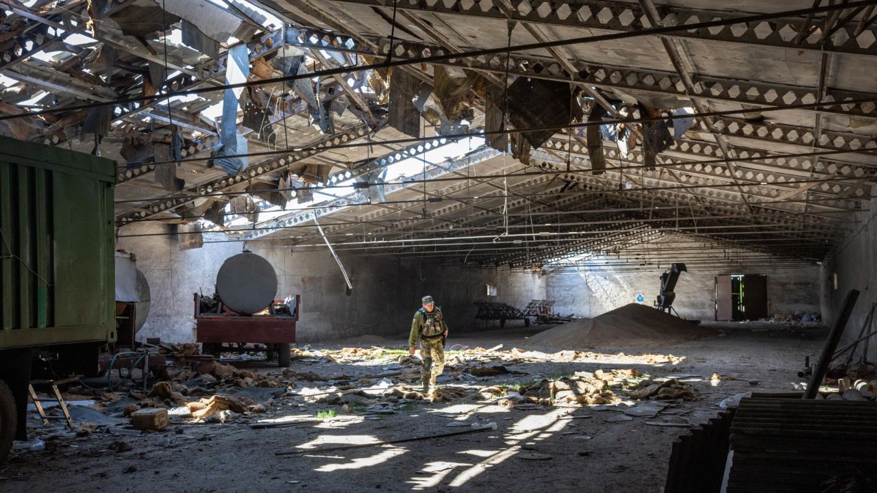 A Ukrainian army officer inspects a grain warehouse shelled by Russian forces on May 6, near Kherson.