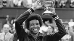 Ashe smiles as he holds the Wimbledon trophy after his upset win over Jimmy Connors in the 1975 final. During his groundbreaking career, Ashe won three grand slams.