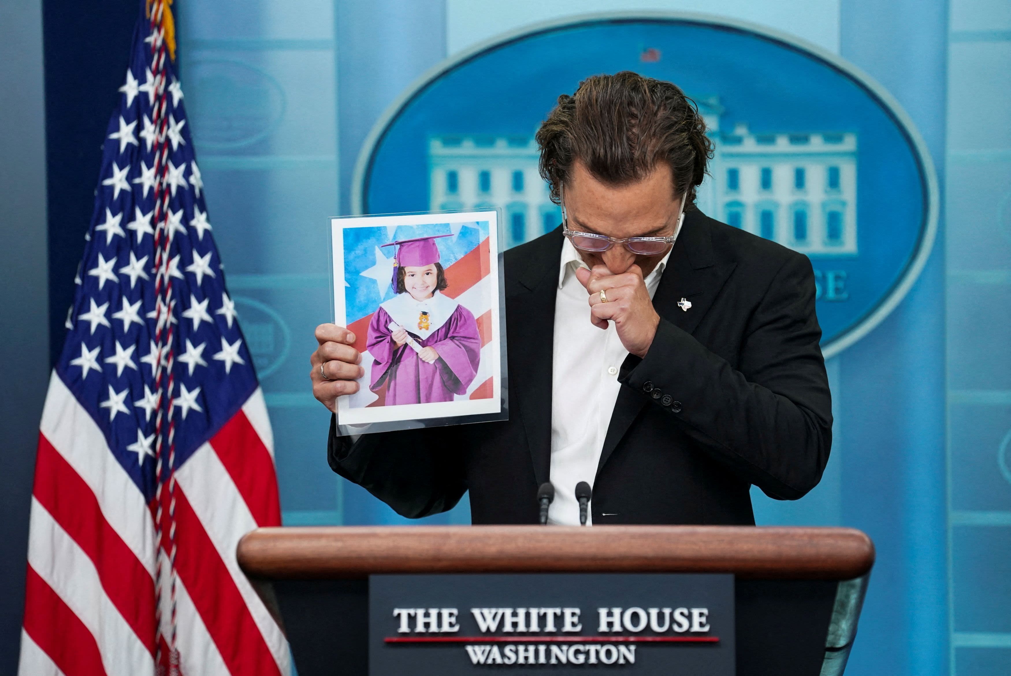 Actor Matthew McConaughey holds up a picture of 10-year-old victim Alithia Ramirez while speaking to reporters.