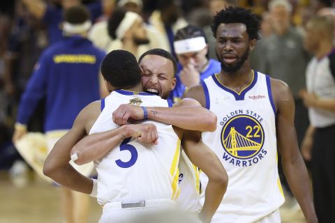 Golden State's Jordan Poole, left, celebrates with teammates Stephen Curry, center, and Andrew Wiggins after scoring against Boston in Game 2 of the NBA Finals on Sunday, June 5. Golden State won the game to tie the series at 1-1, but Boston won Game 3 on Wednesday.