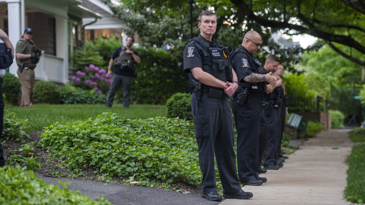 Police officers stand outside the home of US Supreme Court Justice Brett Kavanaugh in anticipation of an abortion-rights demonstration on May 18, 2022, in Chevy Chase, Maryland.