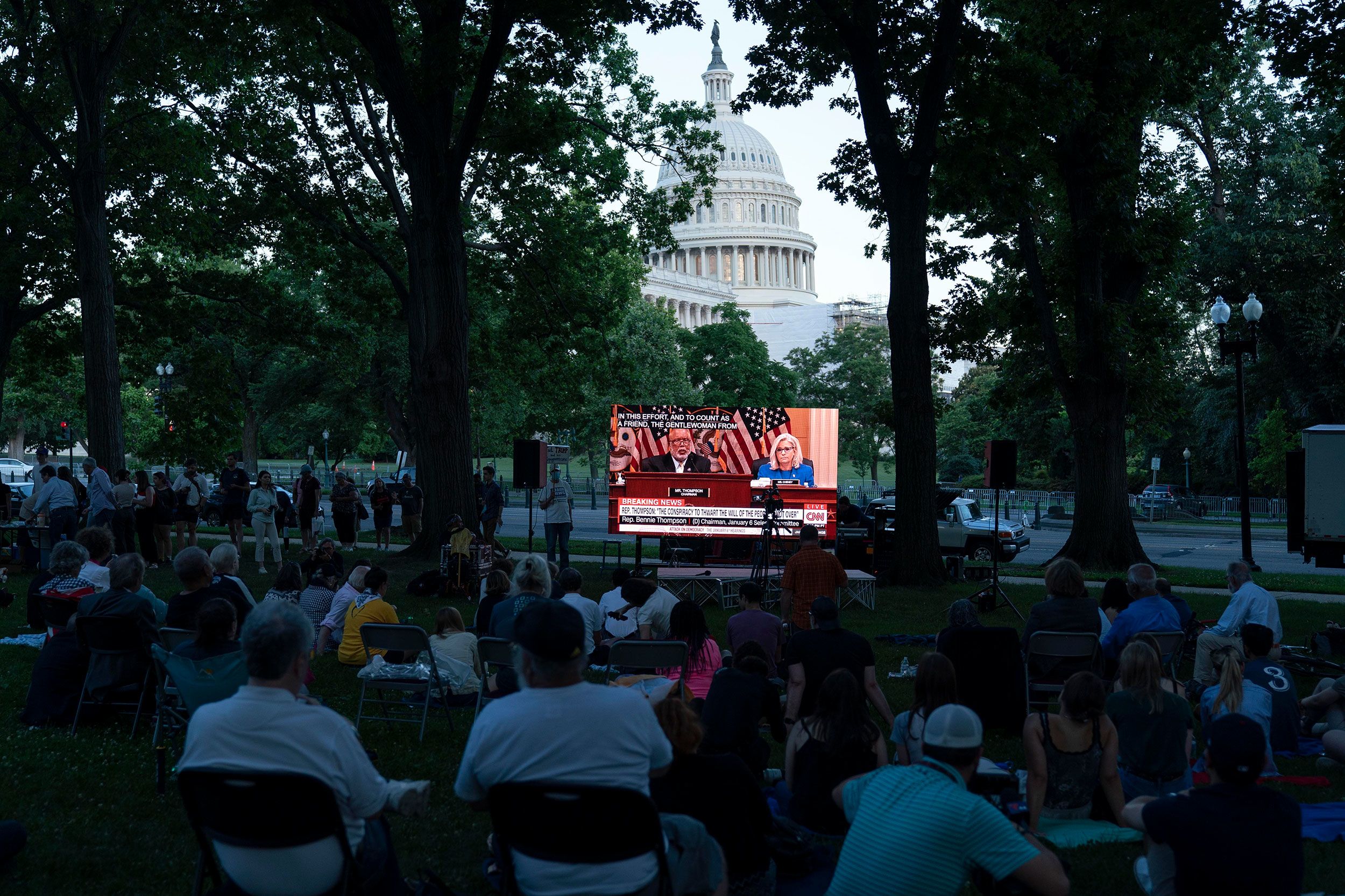 People gather in a park outside the Capitol to watch the hearing on June 9.