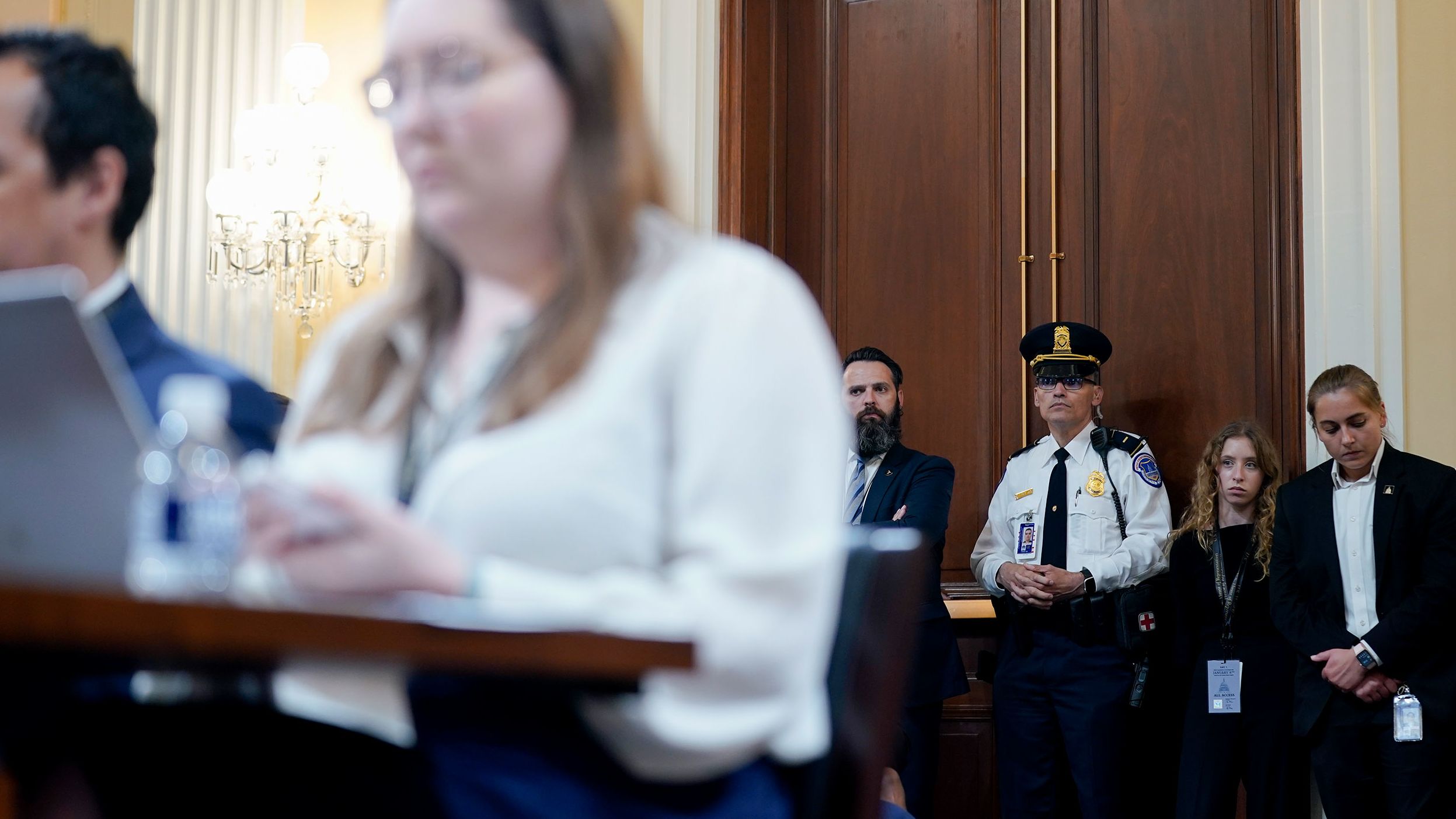 People listen to the proceedings inside the hearing room.