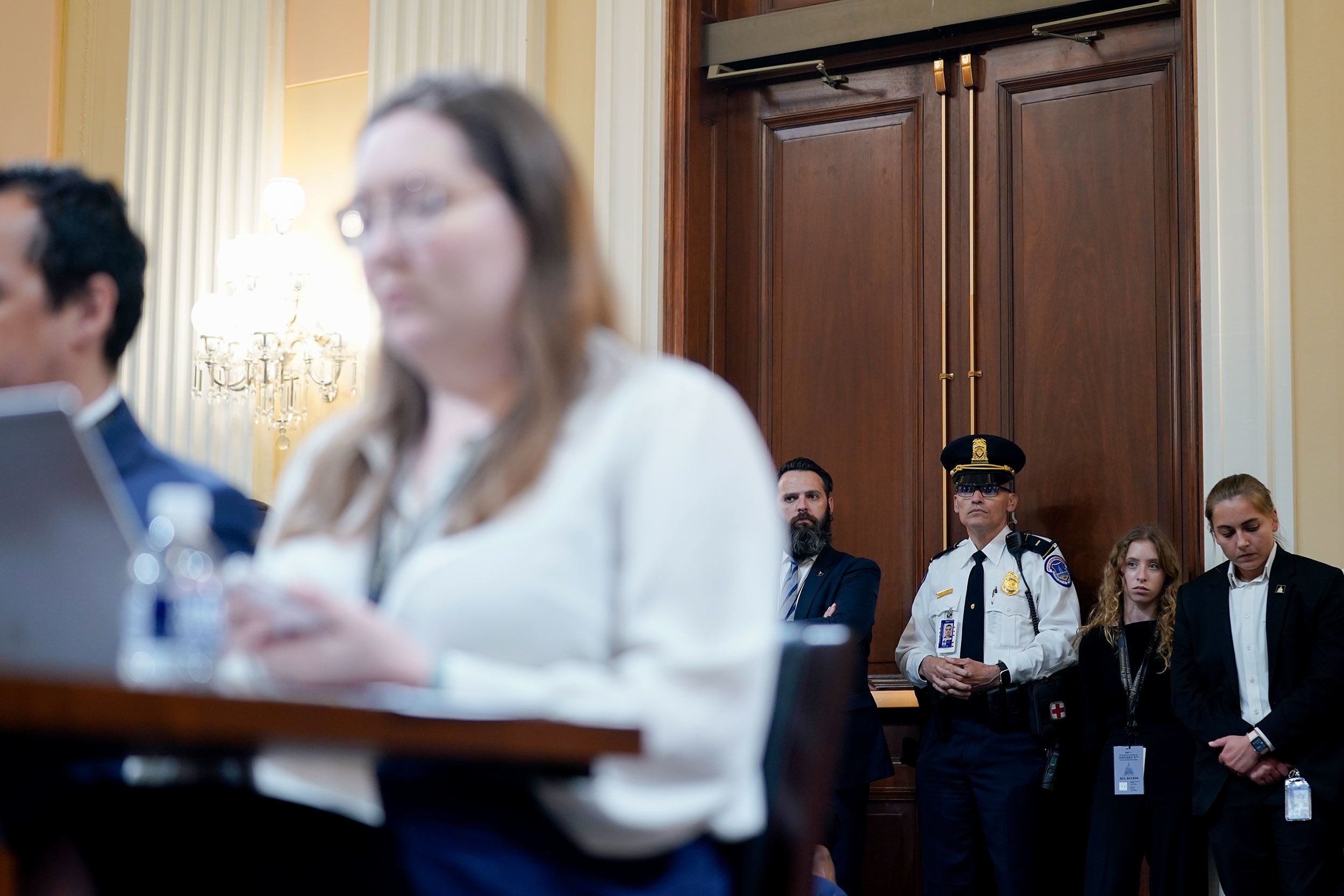 People listen to the proceedings inside the hearing room.