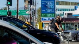 LOS ANGELES, CA-JUNE 1,2022:A bicycle rider maneuvers around motorists stuck in traffic on Cesar E. Chavez Ave., at the intersection of Alameda Street in downtown Los Angeles, where the price of gasoline approaches close to $8 a gallon at the Chevron gas station. (Mel Melcon/Los Angeles Times via Getty Images)