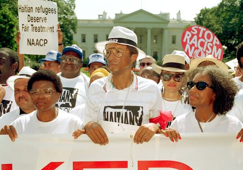 Ashe takes part in a demonstration outside the White House in 1992, protesting  the Bush administration's policy on Haitian refugees. He was later arrested during the protest.