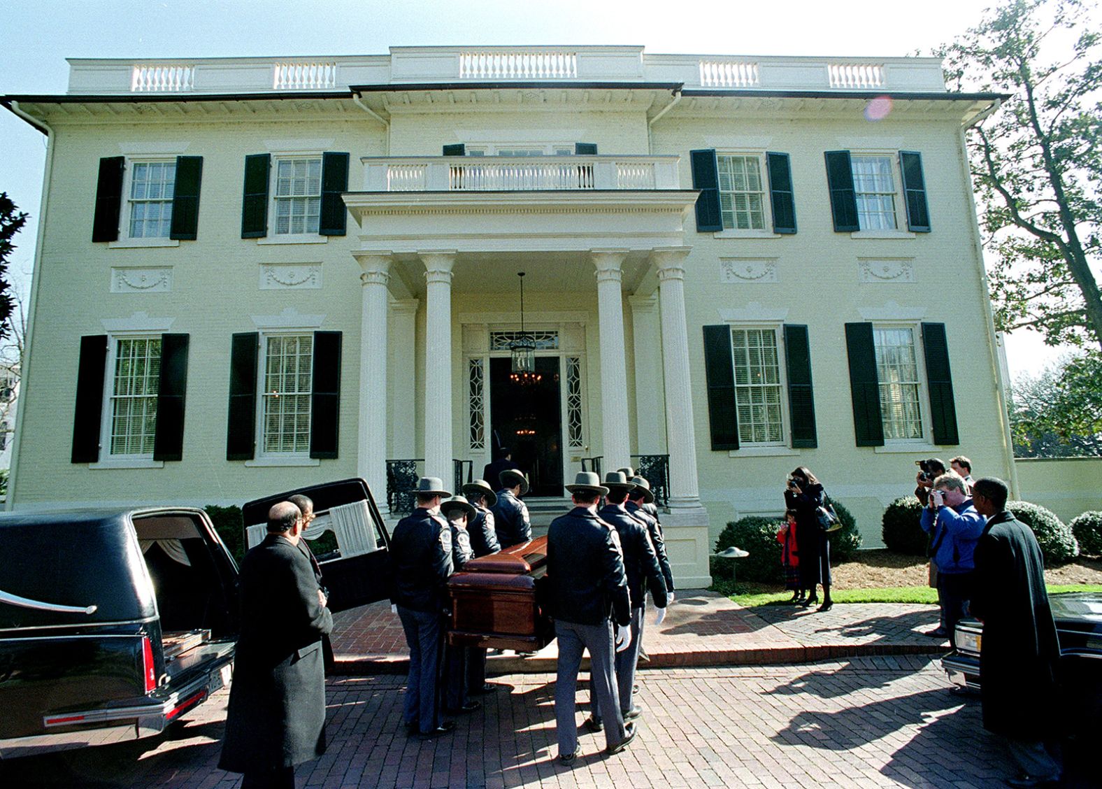 Ashe's casket is carried into the Governor's Mansion in his hometown of Richmond, Virginia, in 1993. A few days earlier, Ashe had died of AIDS-related pneumonia. He was 49 years old. Among those on the right is his widow, Jeanne, a professional photographer. She is with their daughter.