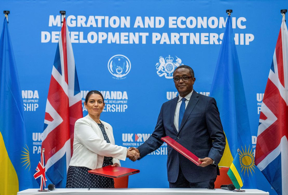 British Home Secretary Priti Patel shakes hands with Rwandan Foreign Minister Vincent Birutaare after signing the partnership agreement at a joint news conference in Kigali, Rwanda, on April 14.
