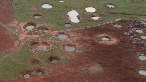 What appear to be ponds are actually water-filled bomb craters from the Vietnam War era, as seen from a helicopter, May 25, 1997, near the northeastern Laotian village of Sam Neau.