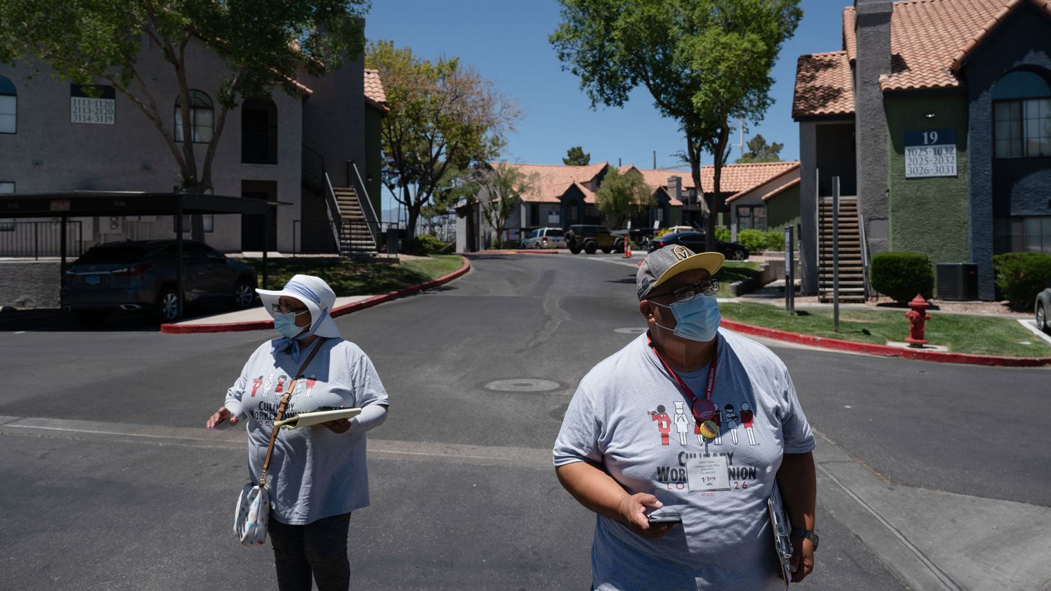 Culinary Union members Mirtha Rojas, left, and Carlos Padilla canvass an apartment complex during early voting for Nevada's primary election on June 1, 2022, in Las Vegas.