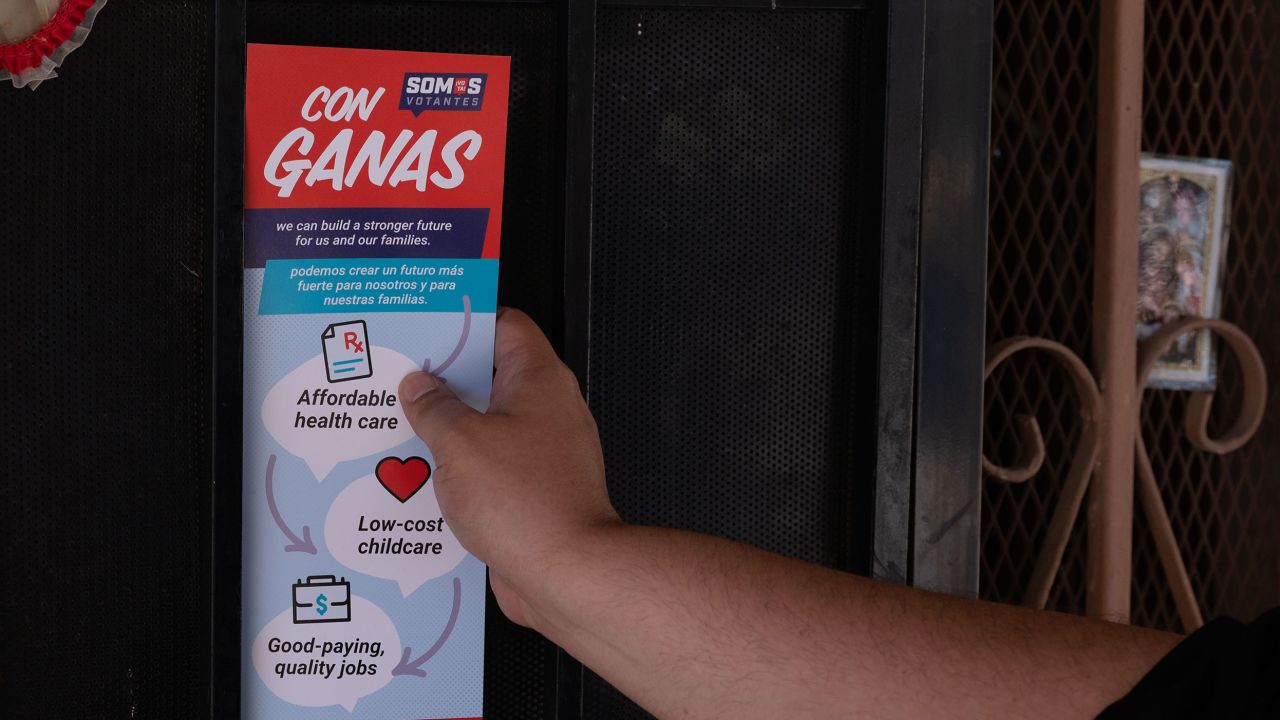 Victor Villanueva of Somos Votantes leaves a flyer behind as he doorknocks in an East Las Vegas neighborhood during the early voting period for Nevada's primary election on June 1, 2022 in Las Vegas, Nevada.