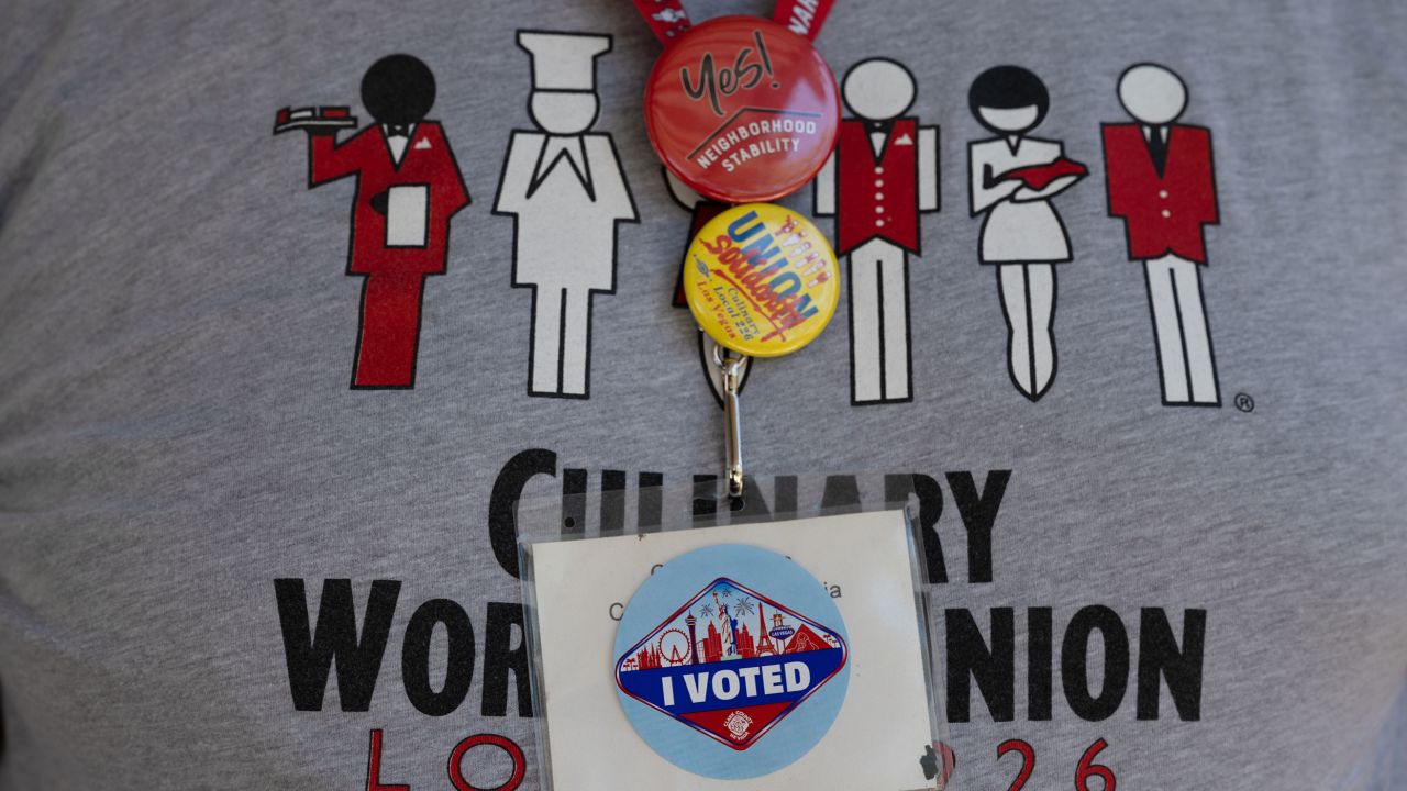 Carlos Padilla wears an "I Voted" sticker on his badge as he and other members from the Culinary Union canvass an apartment complex during Nevada's early voting period on June 1, 2022 in Las Vegas, Nevada.