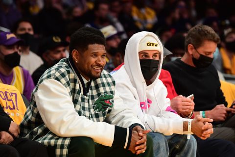 Bieber sits next to R&B singer Usher at an NBA game in Los Angeles in October 2021.