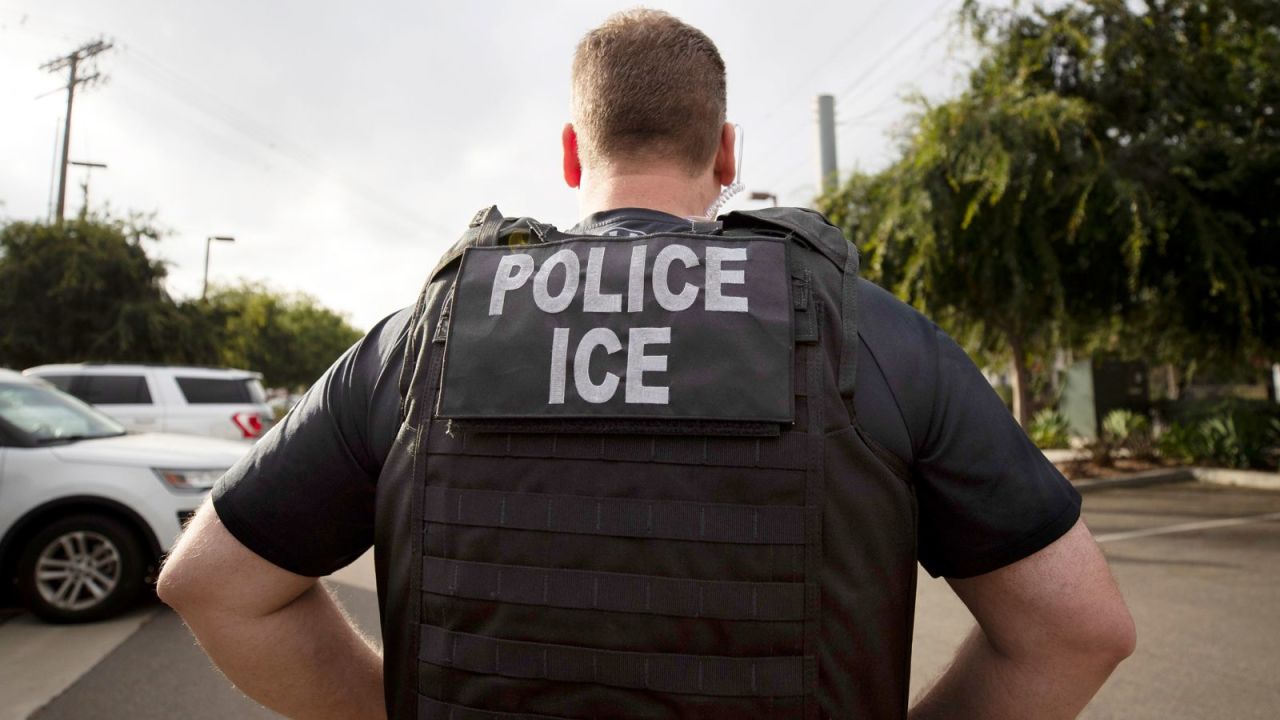 Un oficial de Inmigración y Control de Aduanas observa durante una operación en Escondido, California, el 8 de julio de 2019.