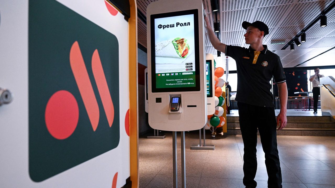 An employee cleans a self-ordering machine at the Russian version of a former McDonald's restaurant before the opening ceremony, in Moscow.