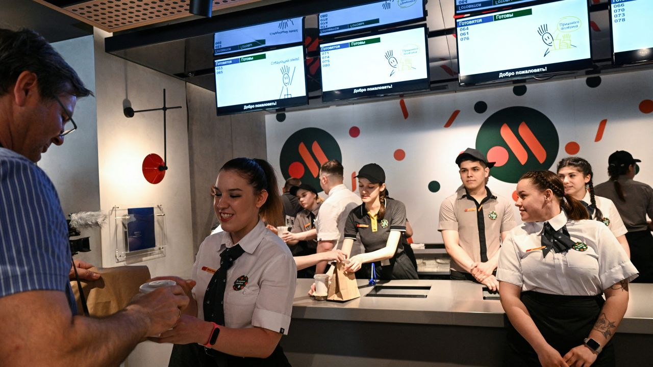 An employee gives a customer his food order at a Vkusno & Tochka restaurant in Moscow, after the opening ceremony.