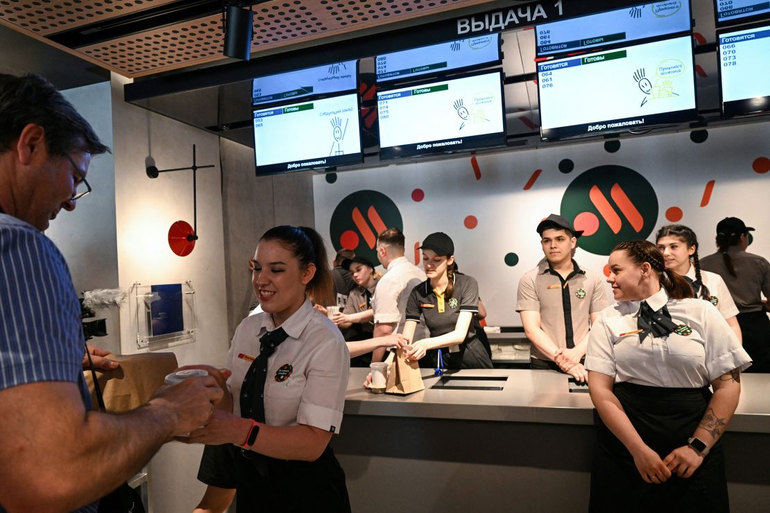 An employee gives a customer his food order at a Vkusno & Tochka restaurant in Moscow, after the opening ceremony.
